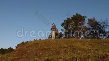 远足女孩喝热茶，享受自然。 女旅行者，<strong>站在山顶</strong>上喝着一杯咖啡